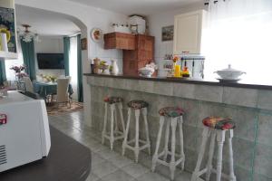 a kitchen with a counter and three stools at La Bica in Bîrnova +35 photos