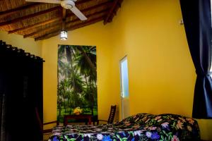 a bedroom with a bed and a yellow wall at Nayan's Paradise in Kottanitivu +44 photos