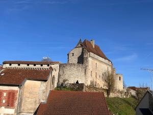 a large castle with a tower on top of some roofs at Maison Lilas in Pontarion