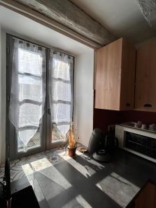 a kitchen with a large window and a microwave at Maison Lilas in Pontarion