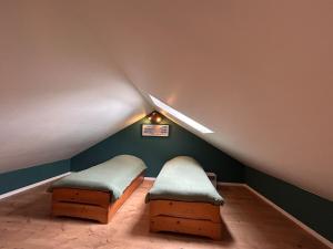 a attic room with two beds and a sloped ceiling at Maison Lilas in Pontarion