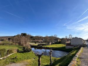 a view of a river with a house in the distance at Maison Lilas in Pontarion +7 photos