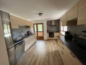 a large kitchen with wooden floors and stainless steel appliances at le saint genest in Vallouise