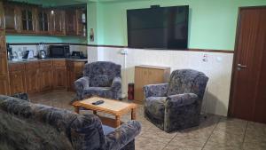 a living room with two chairs and a table at Casa Rosàlia in Castro Daire