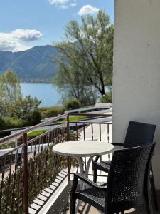 a table and chairs on a balcony with a view of a lake at Hotel Mezzolago in Calceranica al Lago