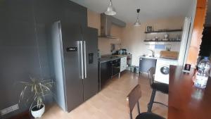a kitchen with a stainless steel refrigerator and a table at Ameli House By PECA in Silleda