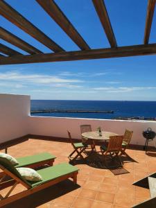 a patio with a table and chairs and the ocean at Casa Miramar in Gran Tarajal