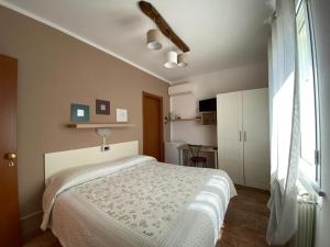 a bedroom with a bed and a large window at Locanda Cà de Rusitta in Vezzi Portio