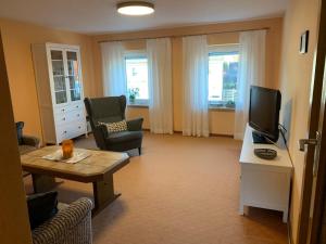 a living room with a tv and a couch and a table at Ferienwohnung Gisela in Lohsa