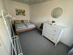 a bedroom with a bed and a dresser and a mirror at Ferienwohnung Gisela in Lohsa