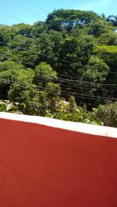 una pared roja con árboles en el fondo en Casa Trancosinho, en Trancoso