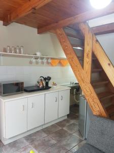 a kitchen with white cabinets and a wooden staircase at LightStone Guesthouse in Centurion