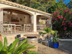 a patio with a table and chairs and flowers at Villa Manoe in Draguignan