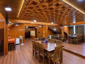 a dining room with wooden floors and tables and chairs at Pine View Resort in Gulmarg +80 photos