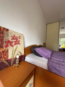 a bedroom with two beds and a painting on the wall at Mercury Apartments Budva in Budva