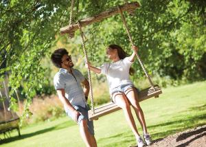 a man and a woman sitting on a swing at Kilminorth Cottages in Trelaske