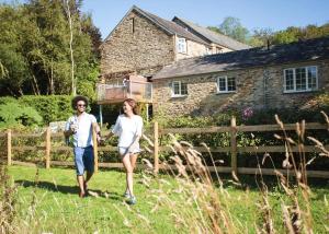 a man and woman walking in front of a house at Kilminorth Cottages in Trelaske