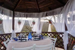 a table with white chairs and a table with a table cloth at La Bica in Bîrnova