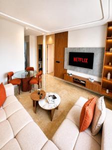 a living room with a couch and a tv at Oasis Hills - Modern & Cosy 1BR with Balcony - Central in Casablanca