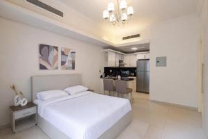 a white bedroom with a bed and a kitchen at El Safwa Resort New Cairo in Cairo