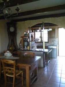 a kitchen with a table and a clock on the wall at Maison campagne in Charron