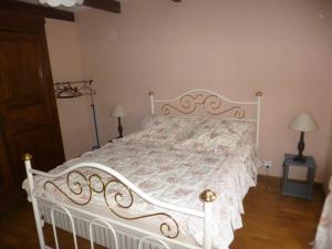 a white bed in a bedroom with two lamps at Maison campagne in Charron