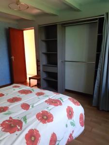 a bedroom with a bed with red flowers on it at Maison campagne in Charron