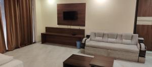a living room with a couch and a tv at Hotel Renuka Inn A Unite shyam ganga builders in Deoria