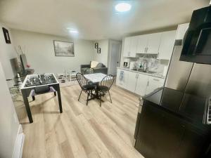 a kitchen and living room with a table and chairs at Airport Getaway- 4 mins from Airport in Dieppe +9 photos