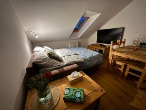 a small bedroom with a bed and a table at Apartmán Kašperk in Vacov