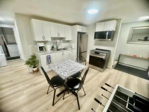 a kitchen with a table and chairs in a room at Airport Getaway- 4 mins from Airport in Dieppe