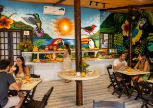a group of people sitting at tables in a restaurant at Beija Flor Pousada in Ubatuba