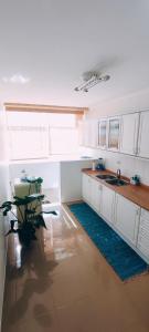 a kitchen with white cabinets and a sink and a plant at Azurara Beach Nest in Azurara
