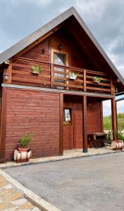a wooden building with a balcony and a table at Brvnare Nikolić in Zlatibor