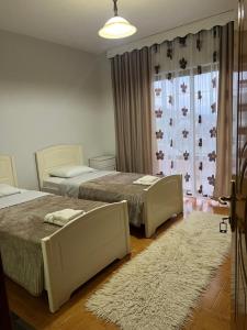 a bedroom with two beds and a rug at Camping & Guest House Herges in Udënisht