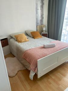 a bedroom with a white bed with orange pillows at Ma première étoile in Joué-lès-Tours
