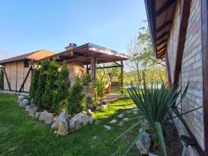 a garden with a pergola next to a house at Drinska Dedovina in Gornja Trešnjica