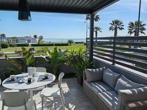 a patio with a couch and a table and chairs at SUITE CONTI 36 terrazza sul mare 2lettini e ombrellone in Porto SantʼElpidio