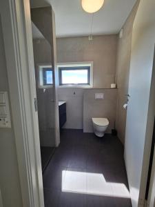 a small bathroom with a toilet and a window at Dugneberg in Karmøy