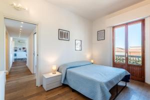 a white bedroom with a bed and a window at Appartamento BePlace - Le Crete in Rapolano Terme