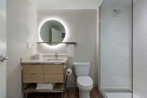 a bathroom with a toilet and a sink and a mirror at TownePlace Suites by Marriott Collierville Memphis in Collierville