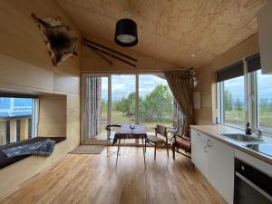 a kitchen and dining room with a table and windows at Guesthouse With Lake View in Veiðilundur