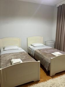 two beds sitting next to each other in a bedroom at Camping & Guest House Herges in Udënisht
