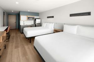 a hotel room with two beds and a kitchen at StudioRes by Marriott Mesa in Mesa