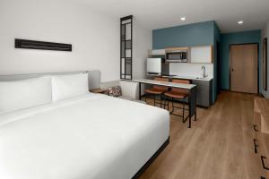 a hotel room with a bed and a kitchen at StudioRes by Marriott Mesa in Mesa