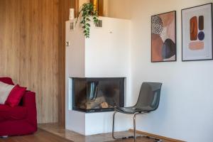 a living room with a chair and a fireplace at Appartamento BePlace - Le Crete in Rapolano Terme