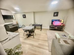 a living room with a tv and a table with chairs at Airport Haven Getaway in Dieppe +15 photos