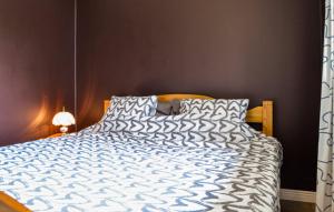 a bedroom with a bed with a blue and white comforter at Magsjön in Surahammar