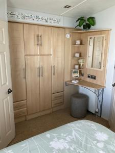 a bedroom with a bed and a desk and cabinets at Konies Place Golden Anchor Free WiFi Bedding Included in Chapel Saint Leonards