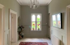 a hallway with a window and a chandelier at Norwood in Rushbrooke
